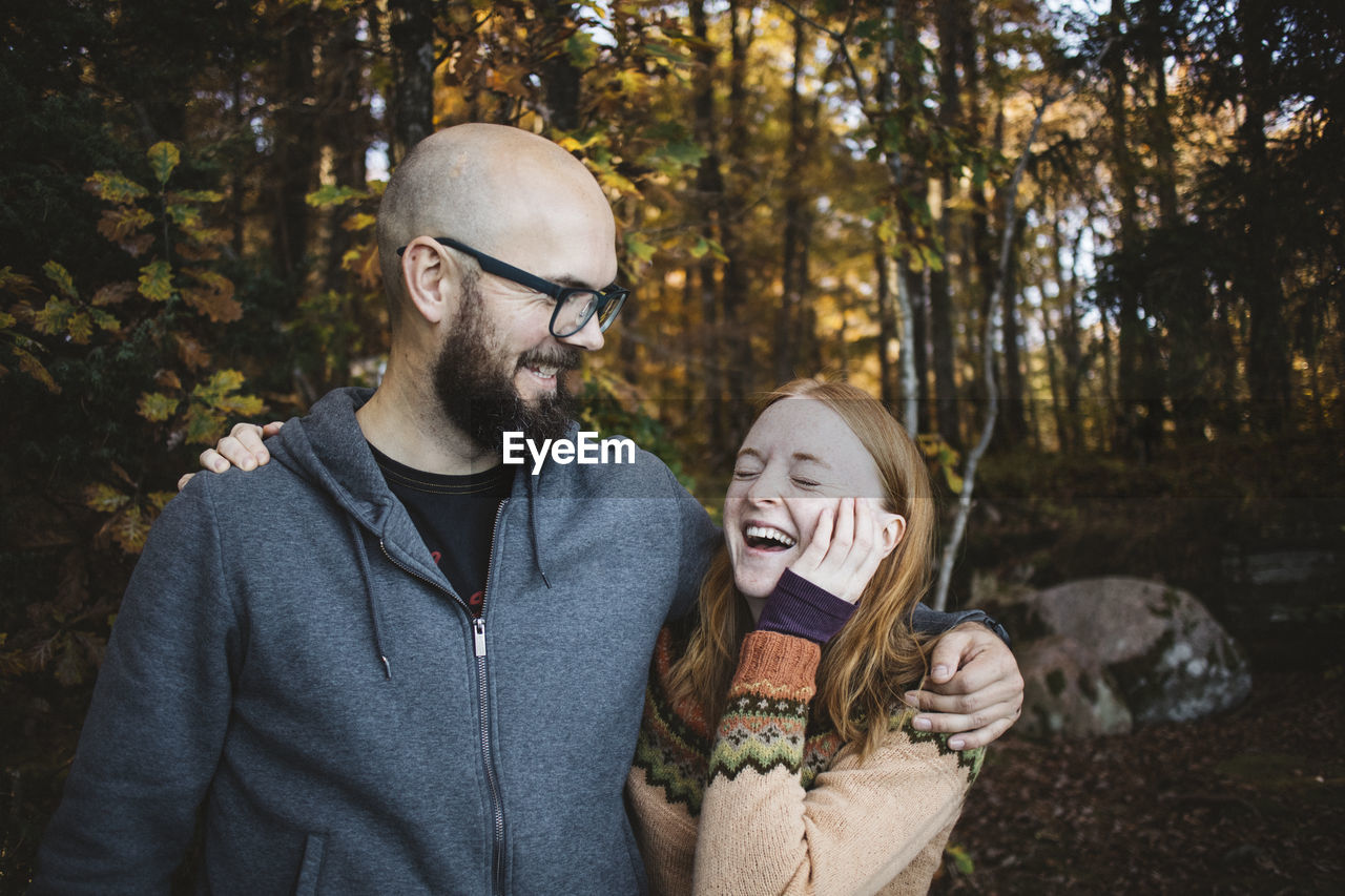 Smiling couple embracing in forest