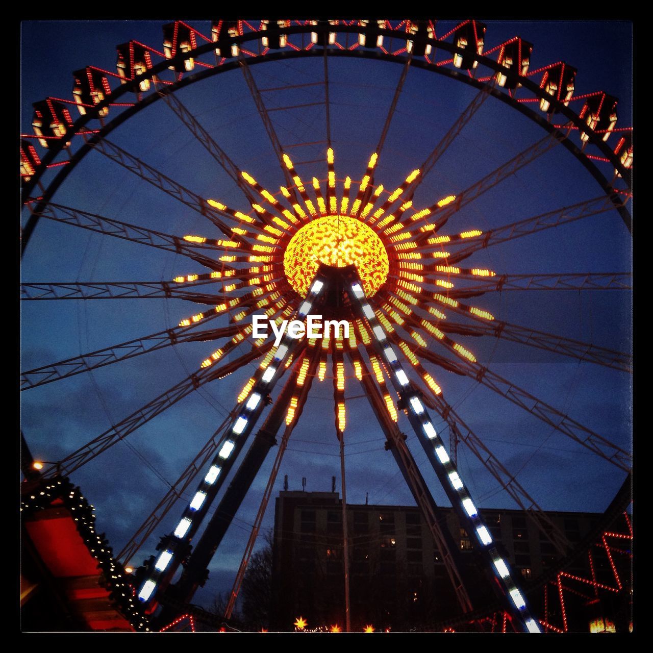 LOW ANGLE VIEW OF FERRIS WHEEL AT NIGHT