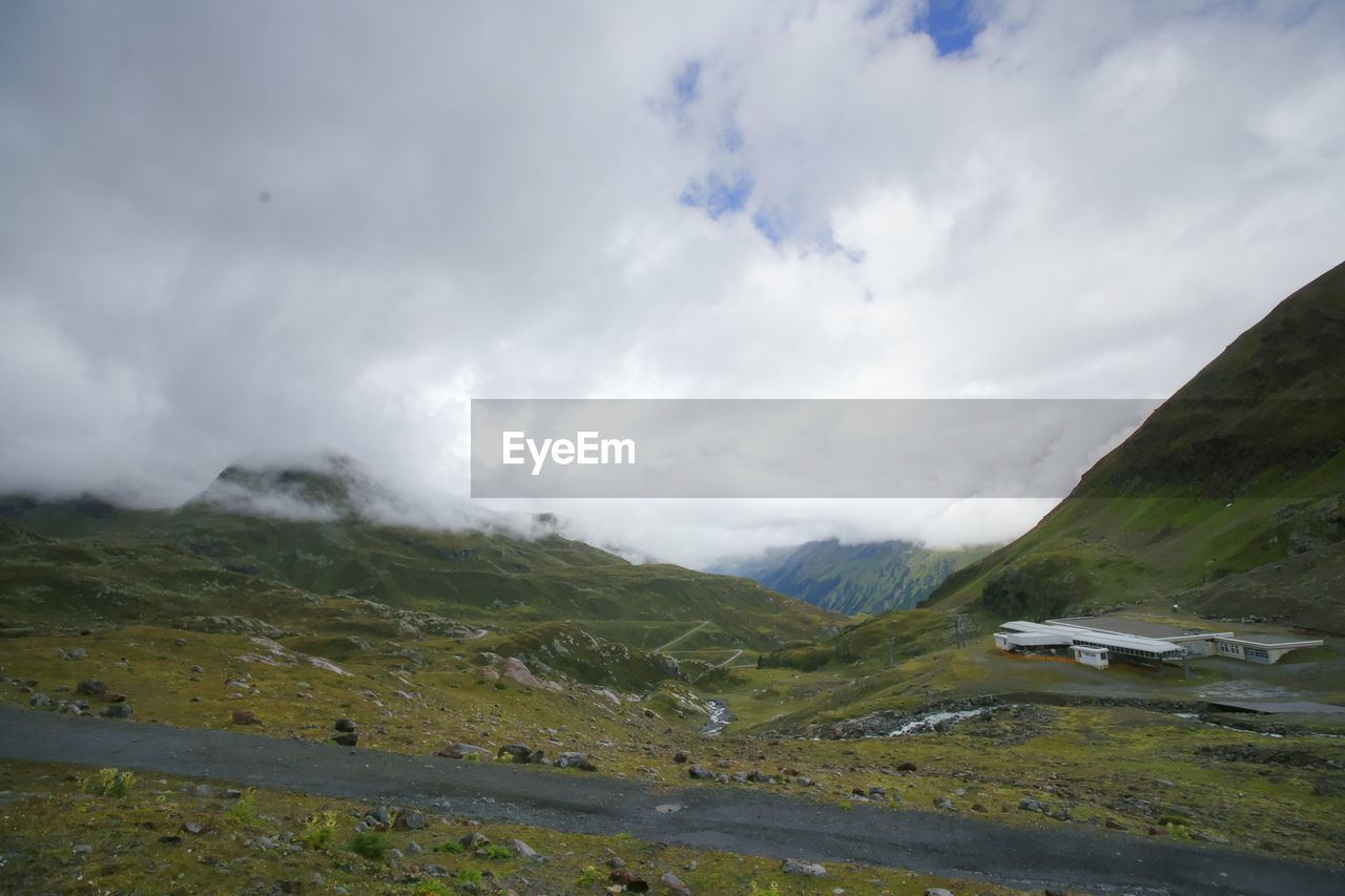 SCENIC VIEW OF MOUNTAINS AGAINST CLOUDY SKY