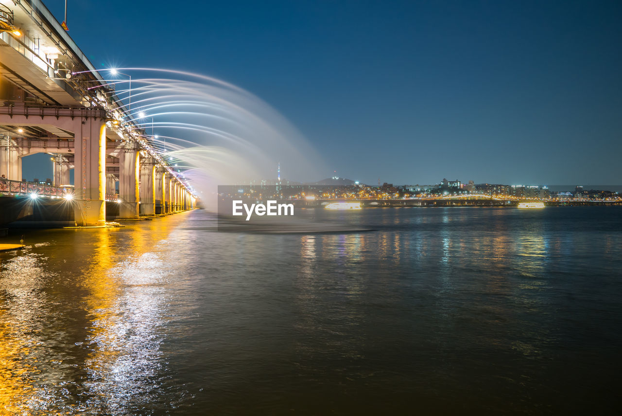 Fountain at banpo bridge over han river against sky at night