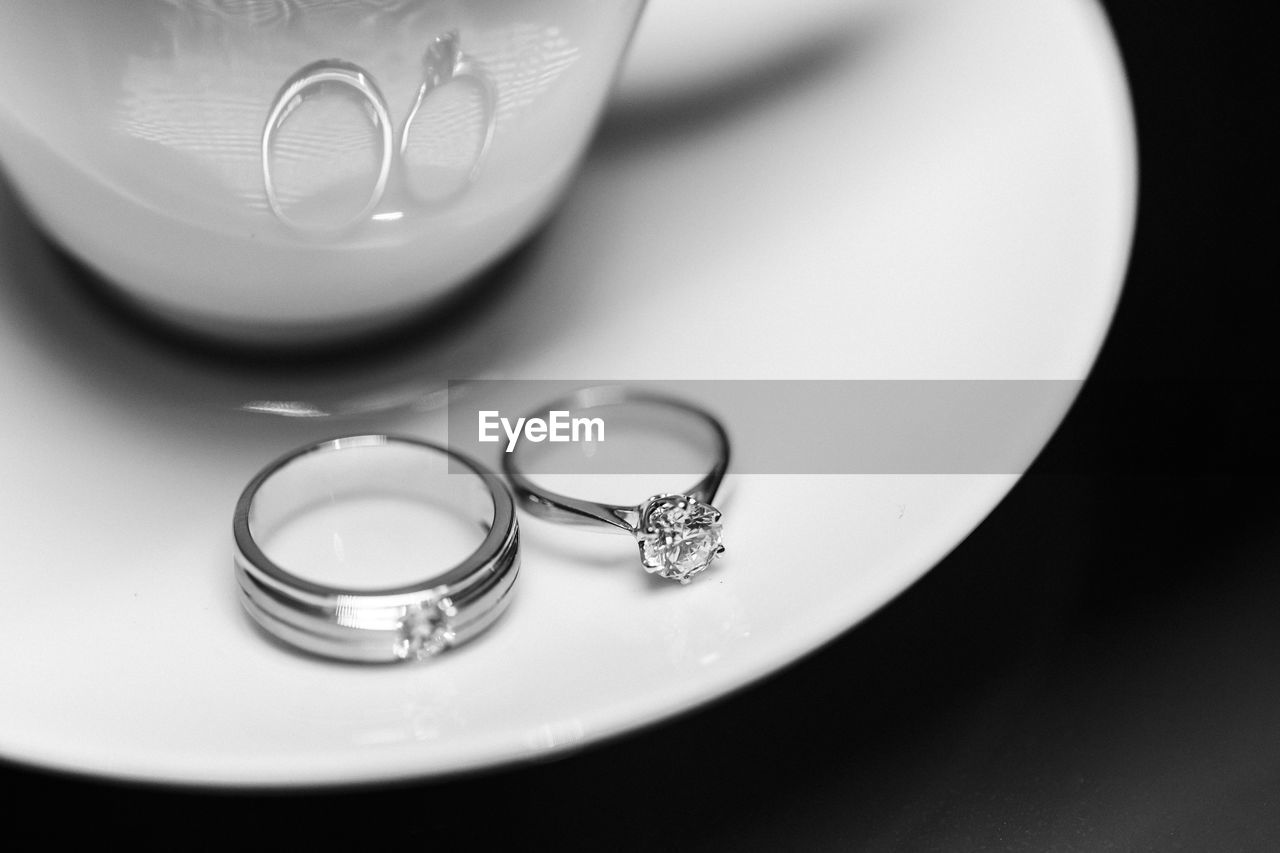 High angle view of wedding rings in saucer on table