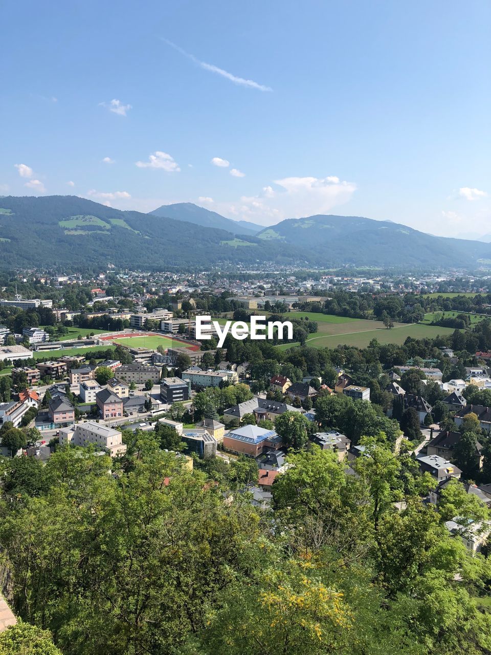 HIGH ANGLE VIEW OF TOWNSCAPE BY MOUNTAINS AGAINST SKY