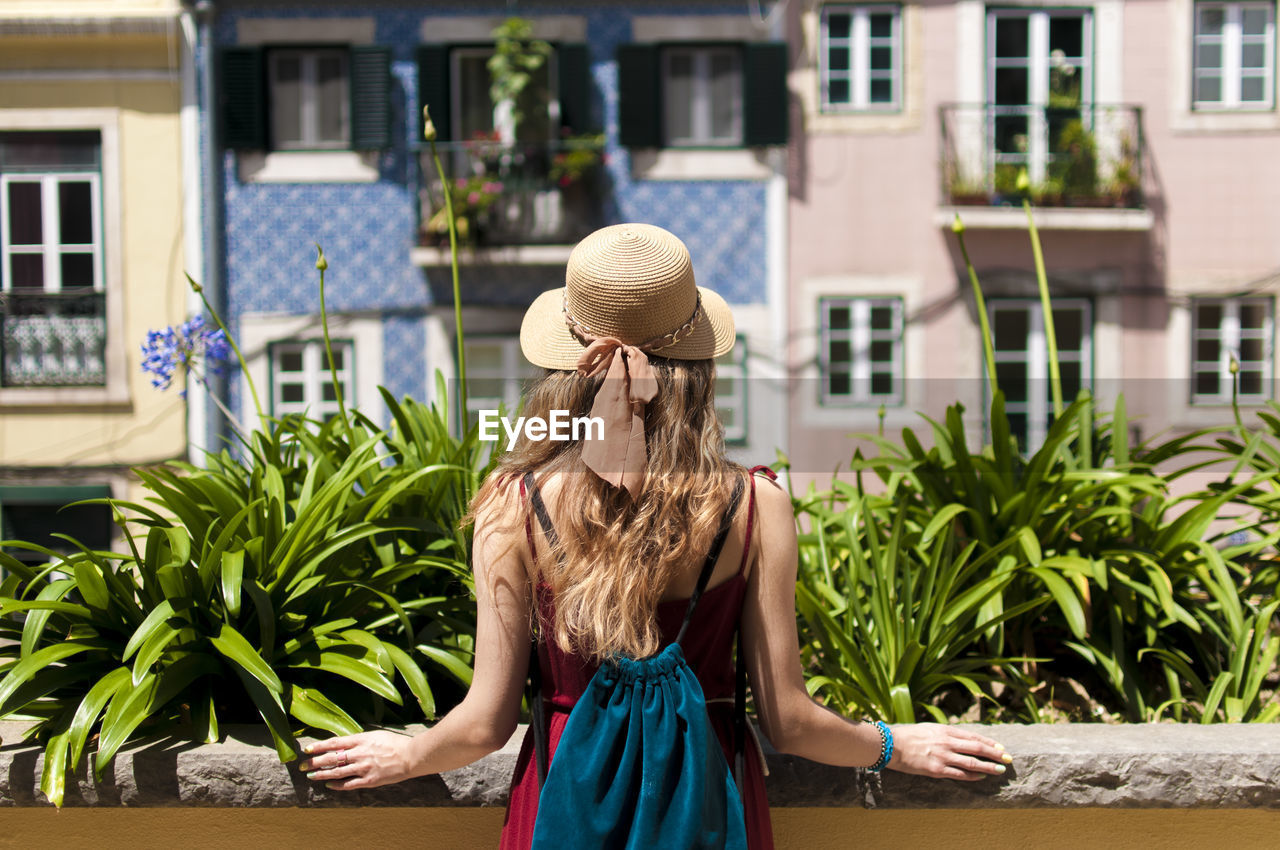 Rear view of woman standing against building