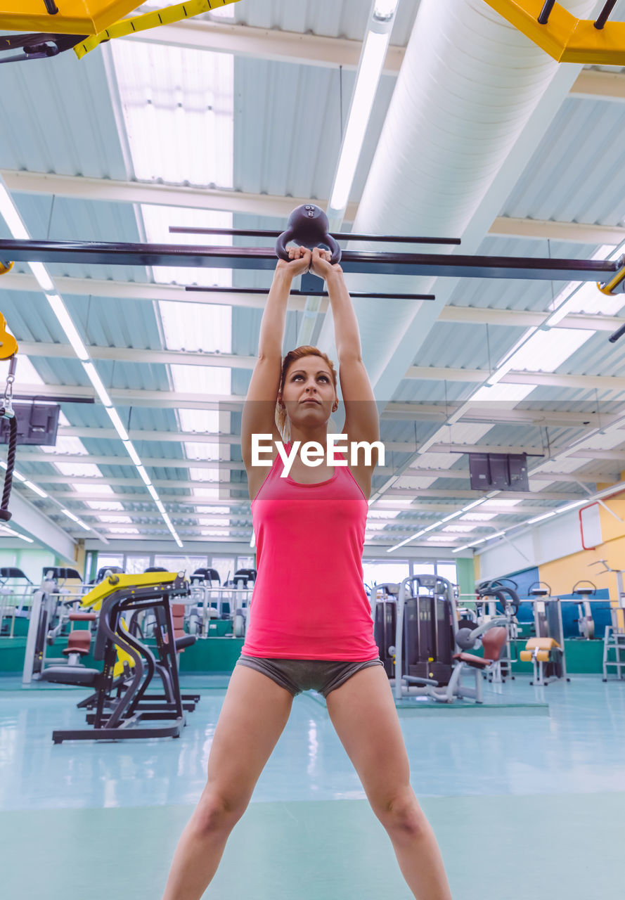 Woman doing exercise with kettlebell at gym