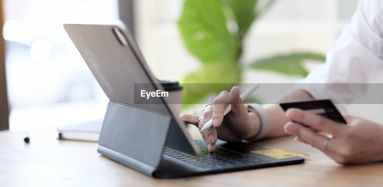 MIDSECTION OF MAN USING LAPTOP