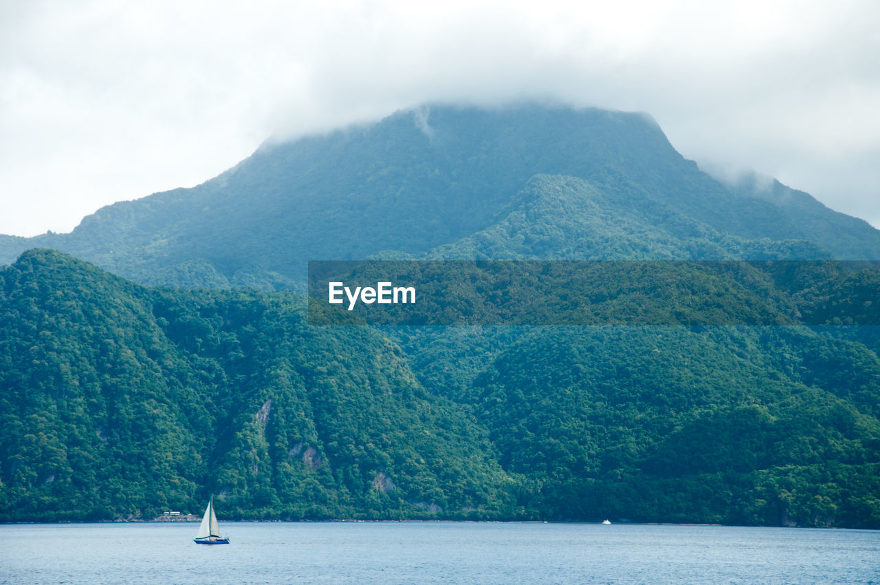 Scenic view of mountain by sea against sky