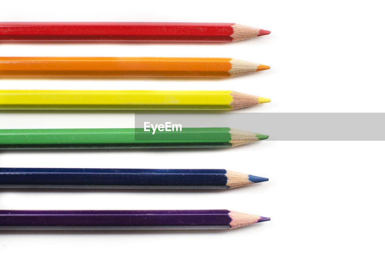 Close-up of multi colored pencils against white background