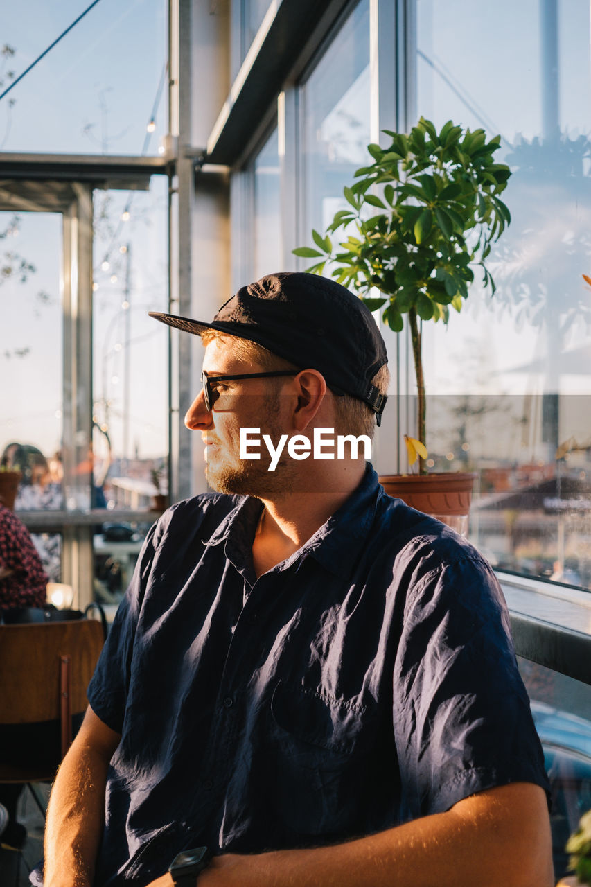 Man looking away while sitting in restaurant