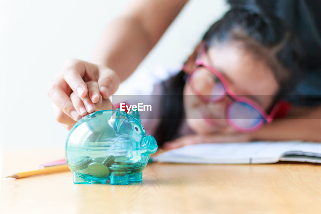 Hands putting coin in piggy bank