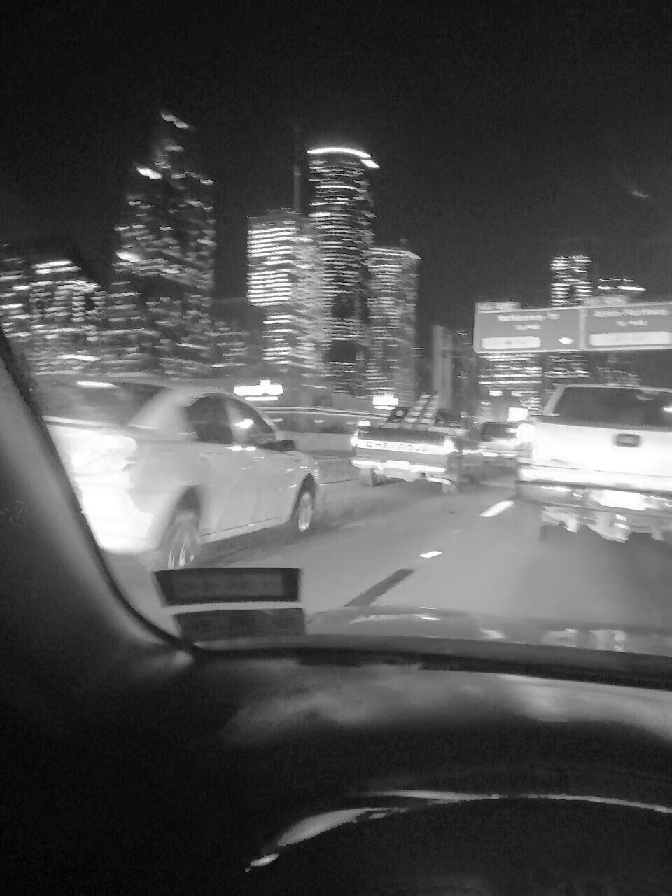 Cars on street seen through windshield at night