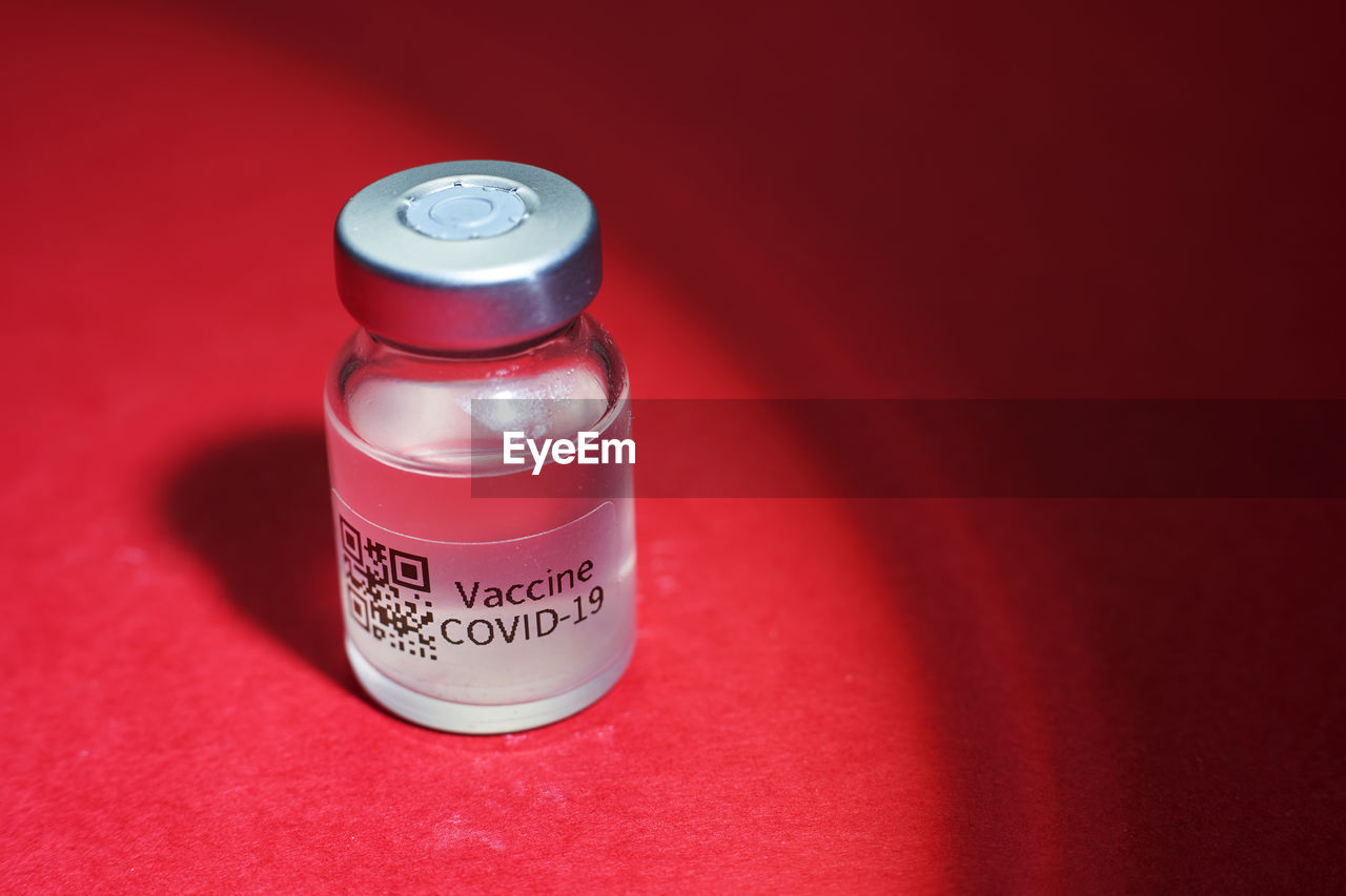 Vaccine bottle on red background