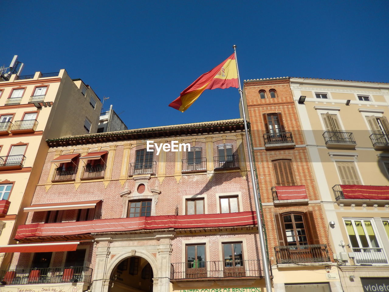 LOW ANGLE VIEW OF FLAG AGAINST BUILDINGS IN CITY