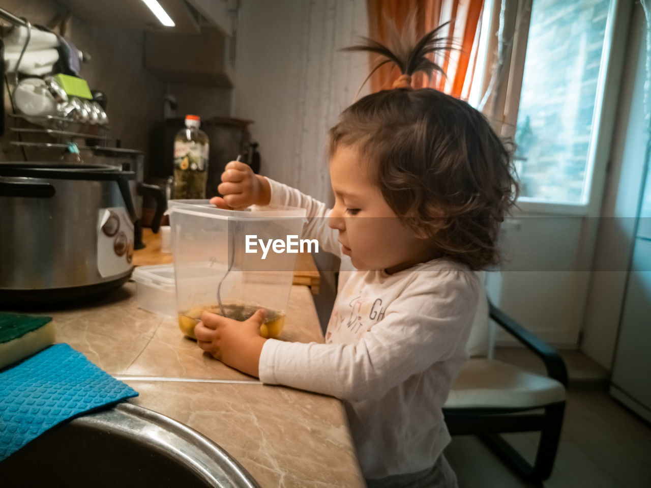 Side view of boy holding camera at home