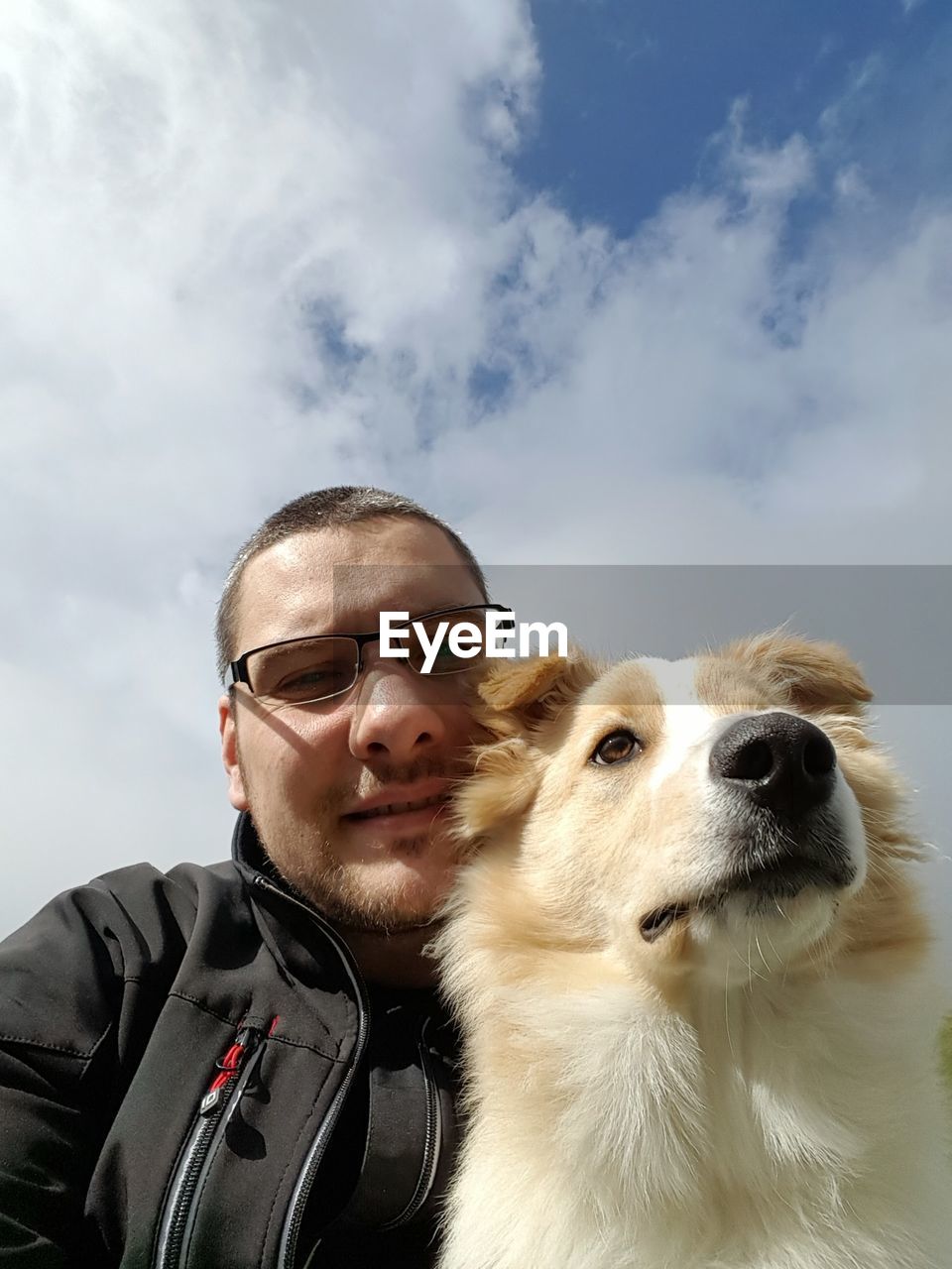 Low angle portrait of man with dog against sky
