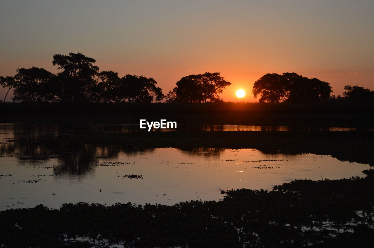 SCENIC VIEW OF LAKE AGAINST ORANGE SKY