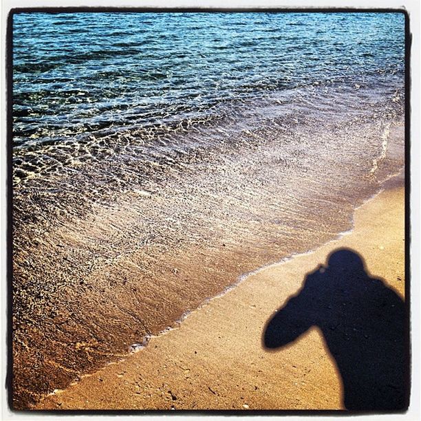 SHADOW OF PEOPLE ON SEA SHORE