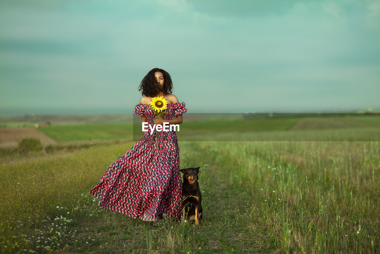 Woman standing on field against sky