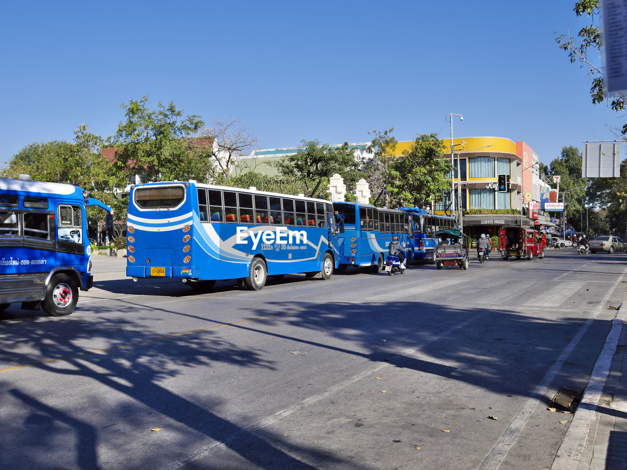 VEHICLES ON ROAD AGAINST BLUE SKY