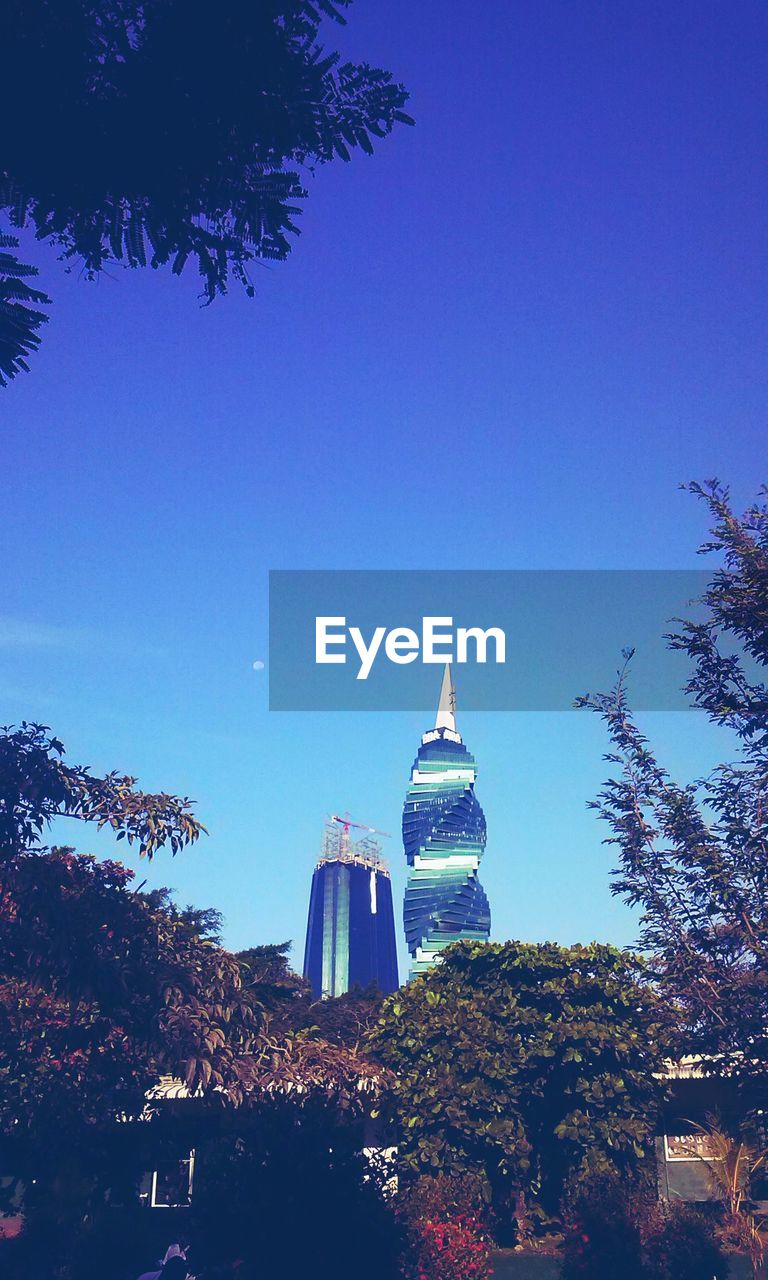 LOW ANGLE VIEW OF BUILDINGS AGAINST CLEAR BLUE SKY