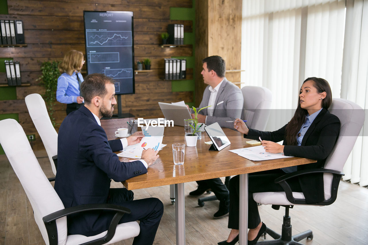 Businesswoman giving presentation to colleagues in office