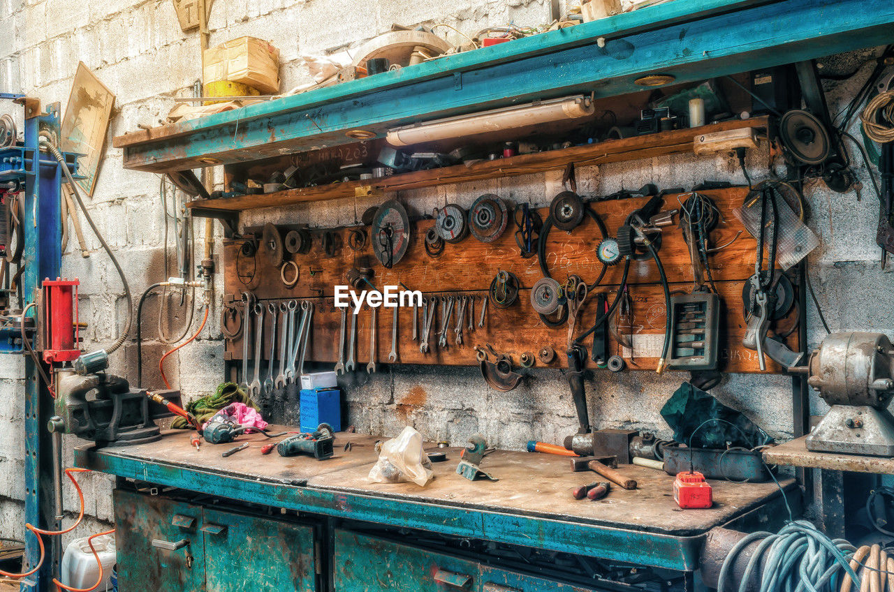 Vintage workshop. antique tools hang on wall, repair equipment on the table. side view.