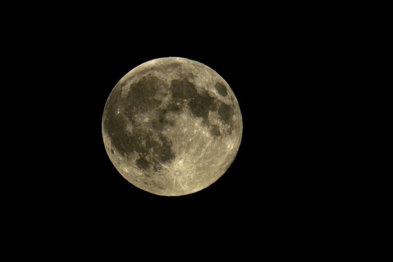 Low angle view of full moon against sky at night