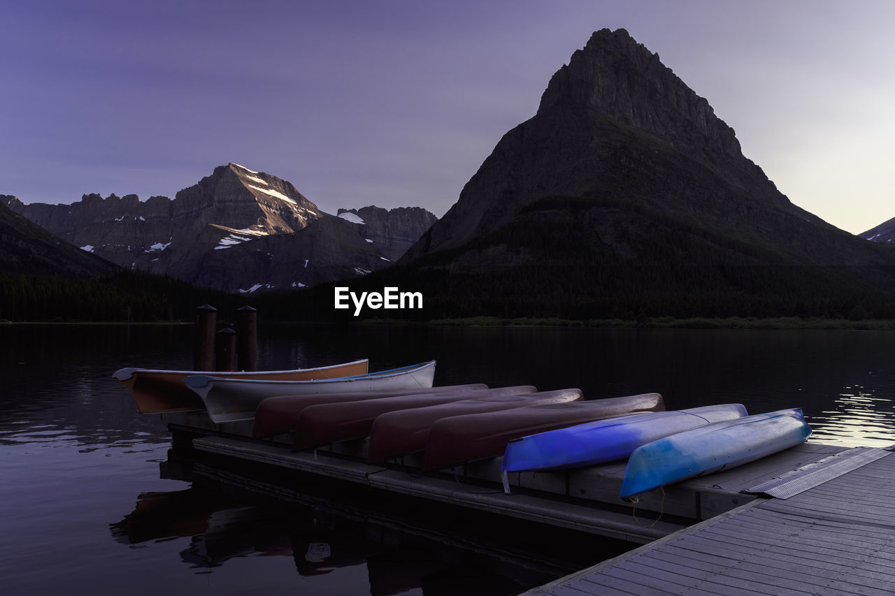 Boats moored in lake against sky