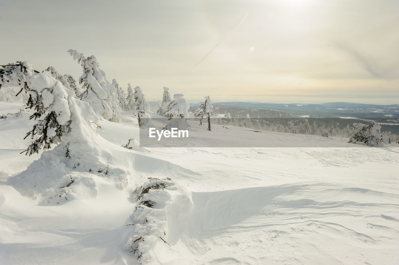 Snow covered landscape against sky