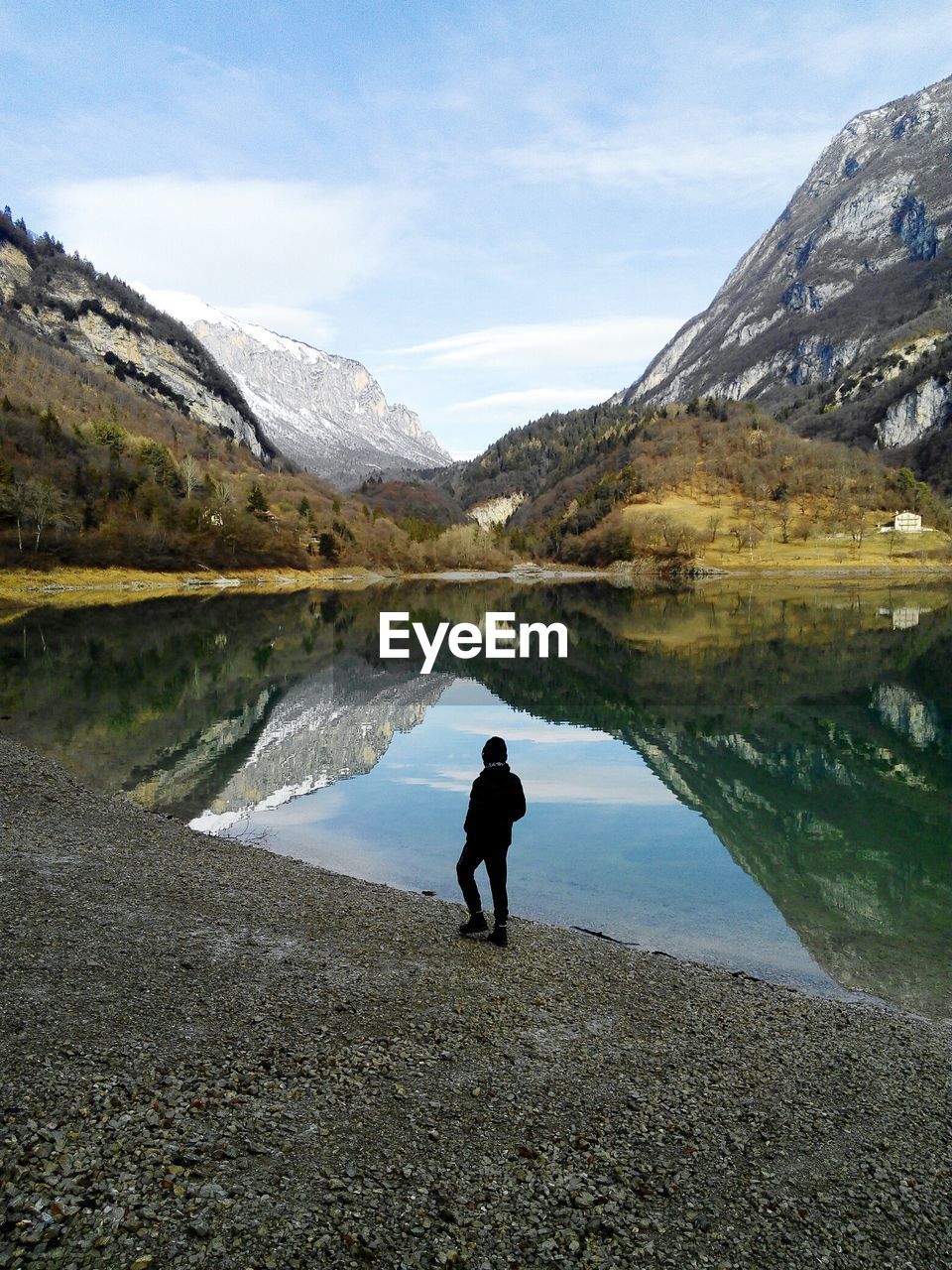 High angle view of person standing by lake against mountains 