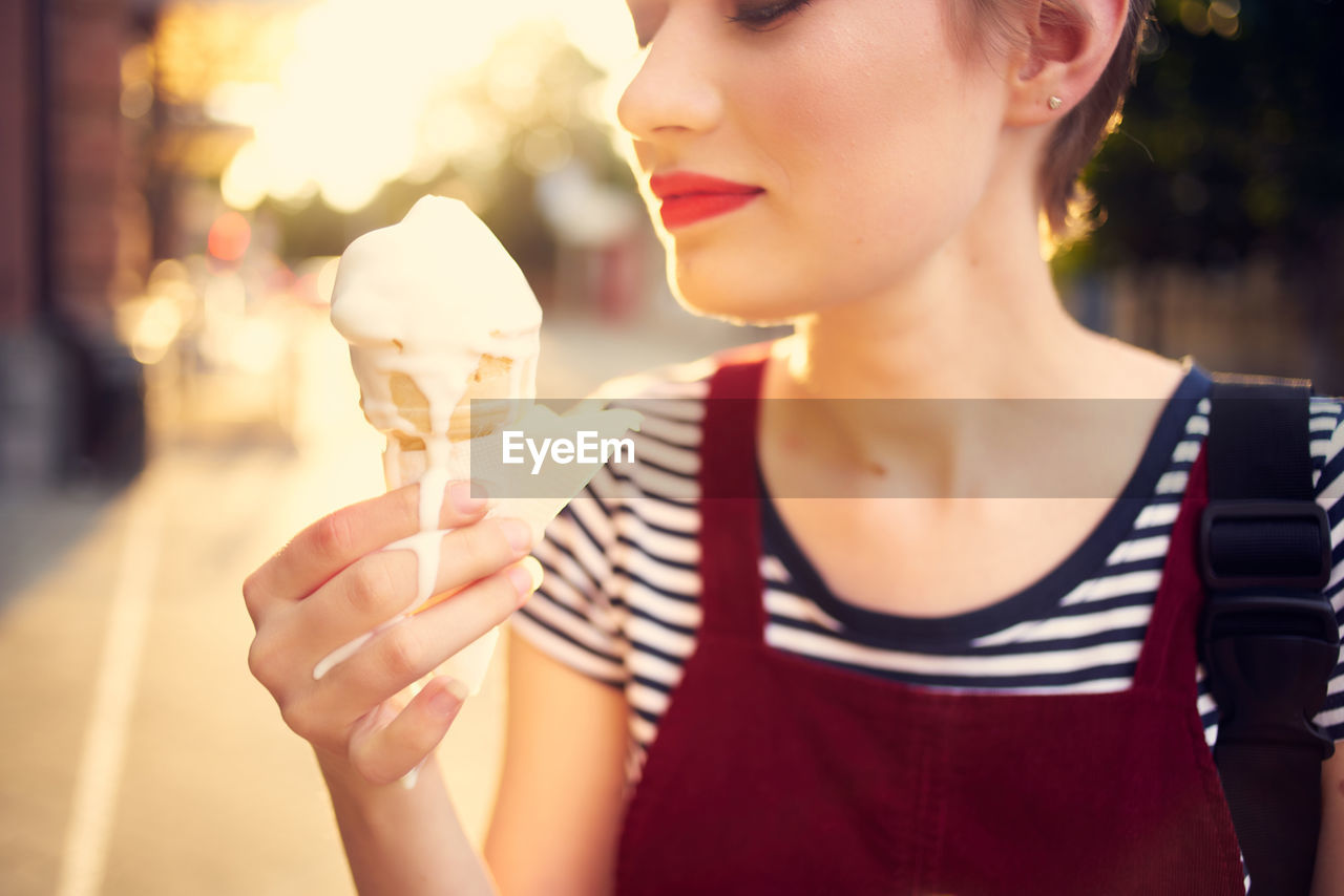 CLOSE-UP OF WOMAN HOLDING ICE CREAM CONE