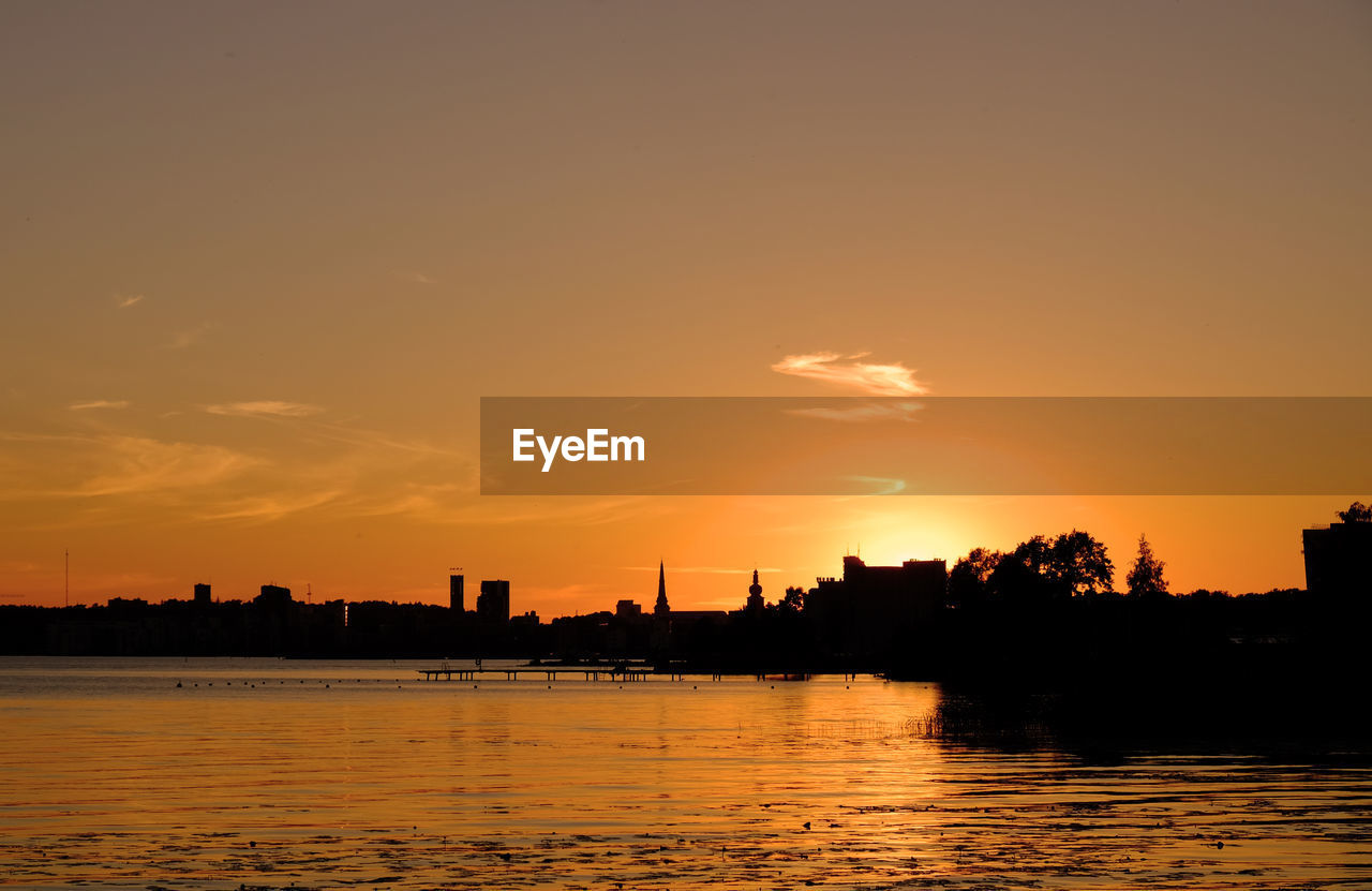 Scenic view of river against sky at sunset