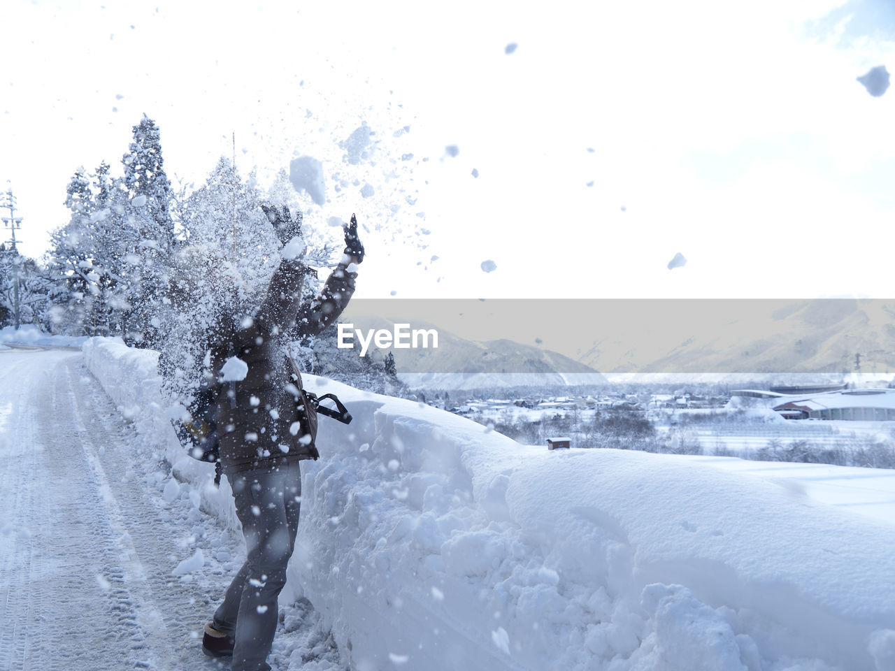 REAR VIEW OF PERSON ON SNOWCAPPED MOUNTAINS