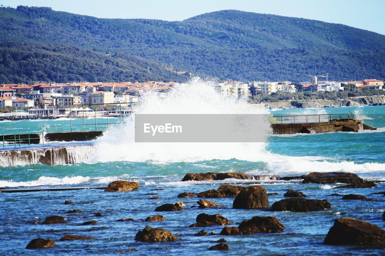 SCENIC VIEW OF SEA AGAINST MOUNTAINS