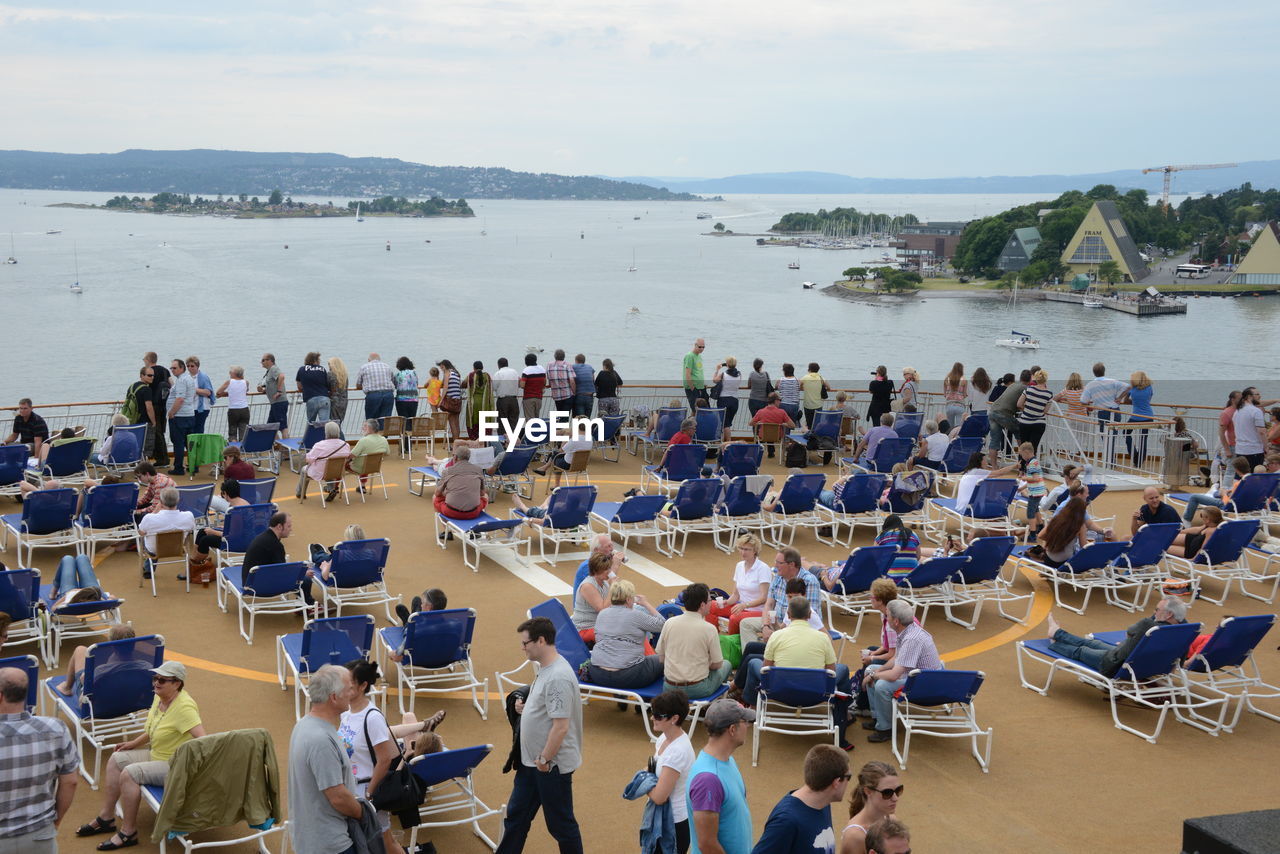 High angle view of people sitting on beach by sea