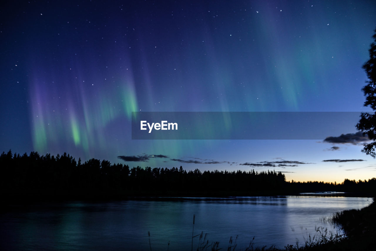 Scenic view of lake against sky at night