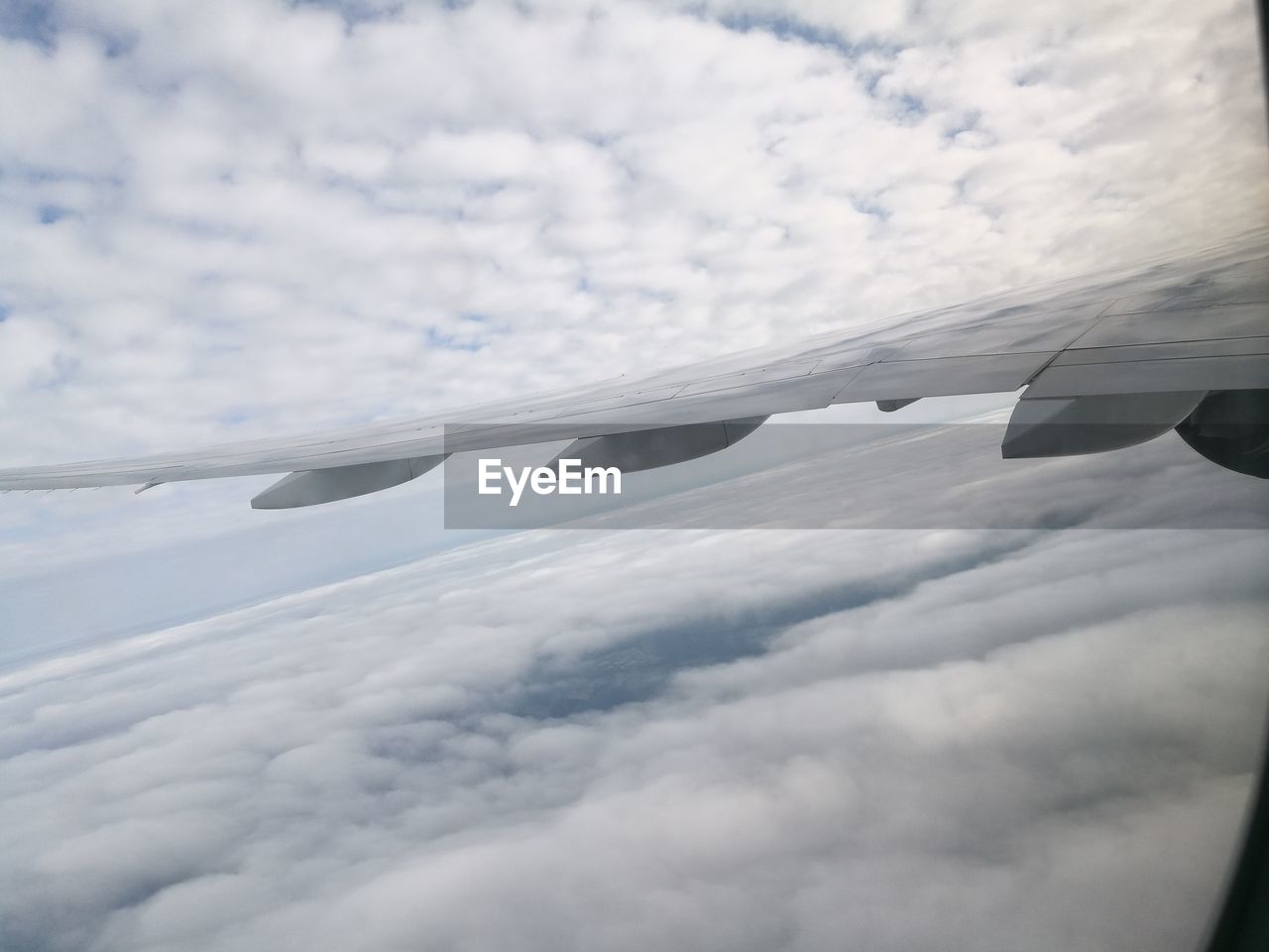 CLOSE-UP OF AIRPLANE WING OVER CLOUDS