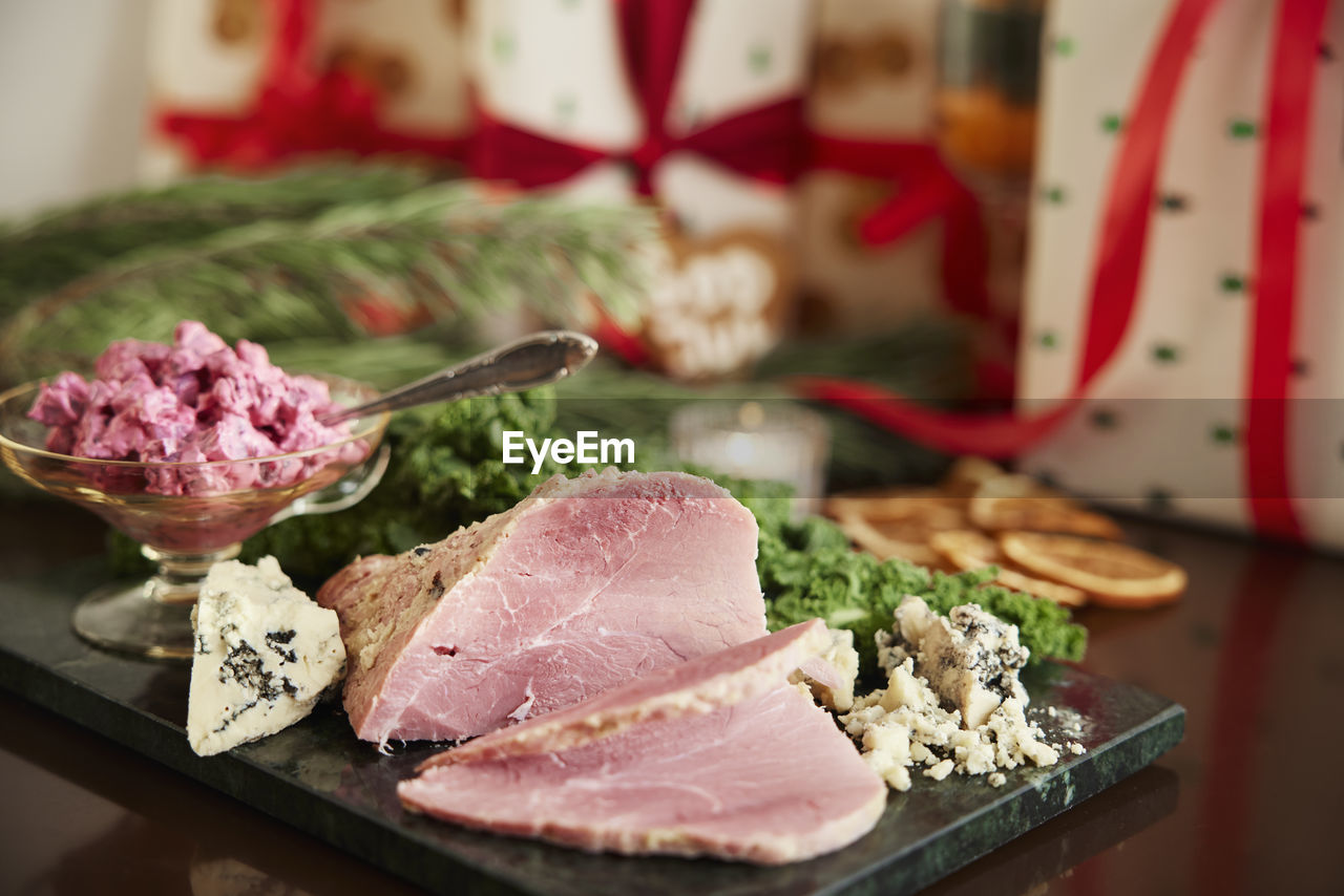 Christmas ham and presents on table