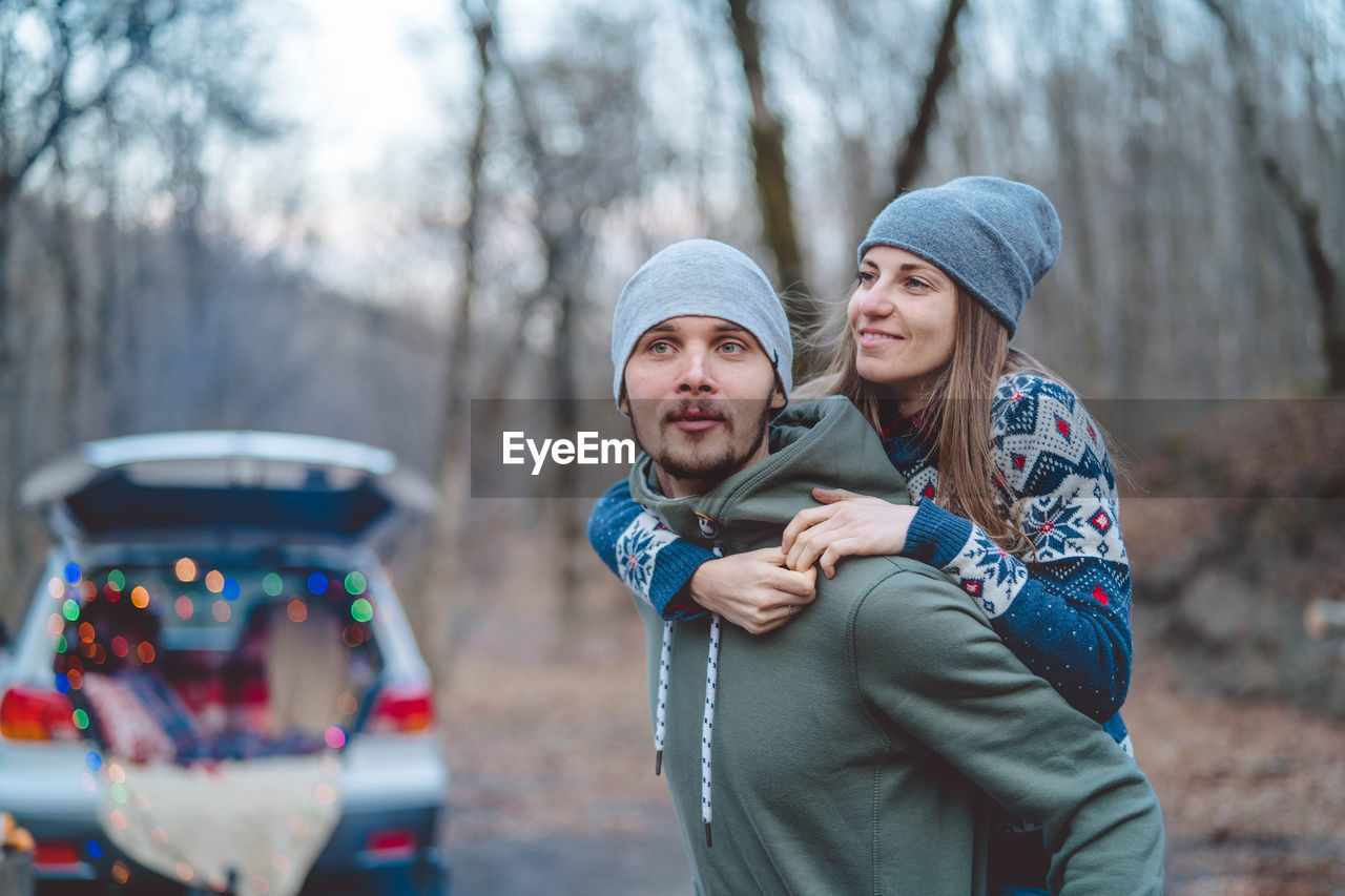 Man carrying girlfriend in forest