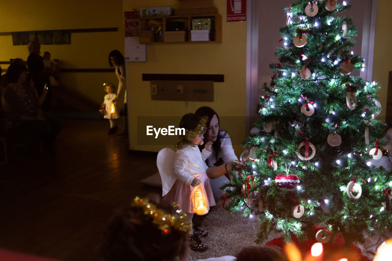 Rear view of women in illuminated christmas tree