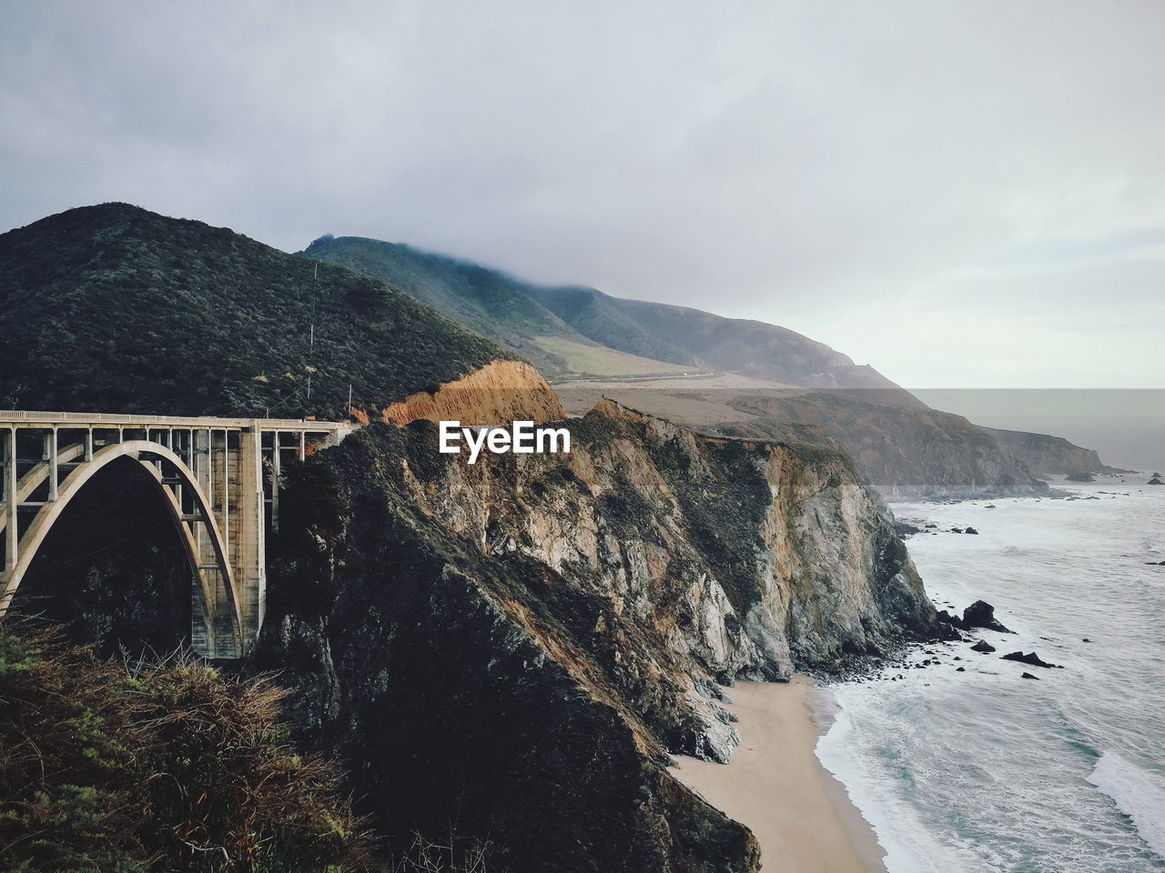 Arch bridge over sea against sky