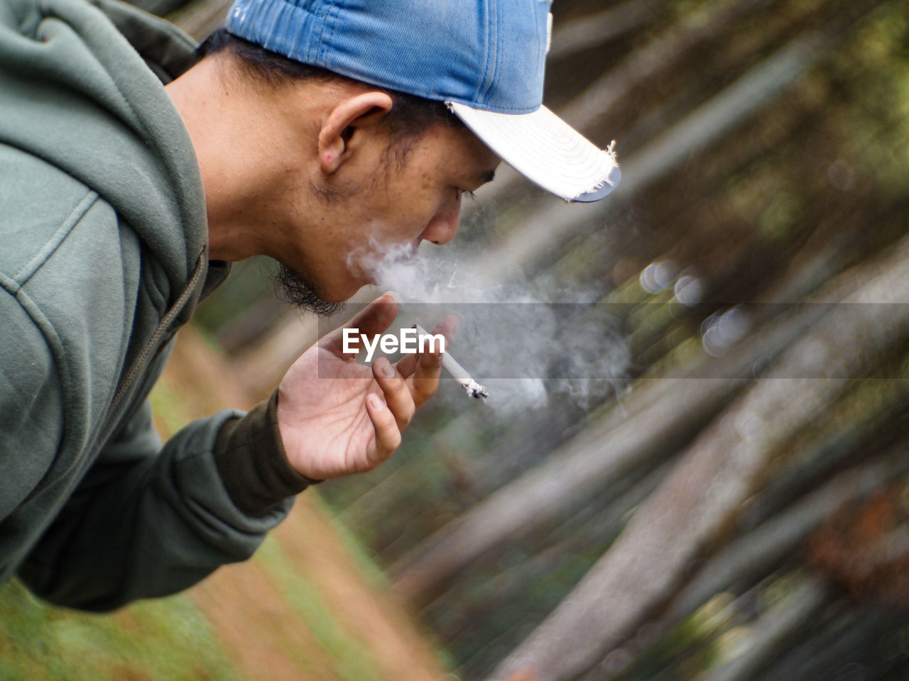 The view of a man smoking in the middle of the forest