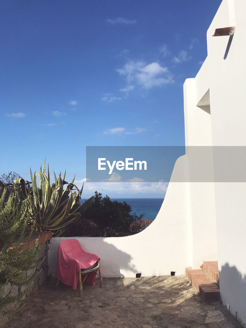 sky, nature, architecture, no people, built structure, cloud, travel destinations, land, plant, building exterior, day, furniture, blue, building, outdoors, travel, sunlight, vacation, beach, white, chair, beauty in nature