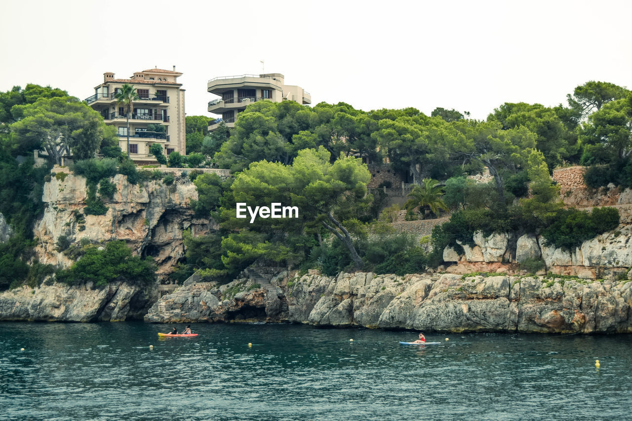 Scenic view of sea by buildings against clear sky