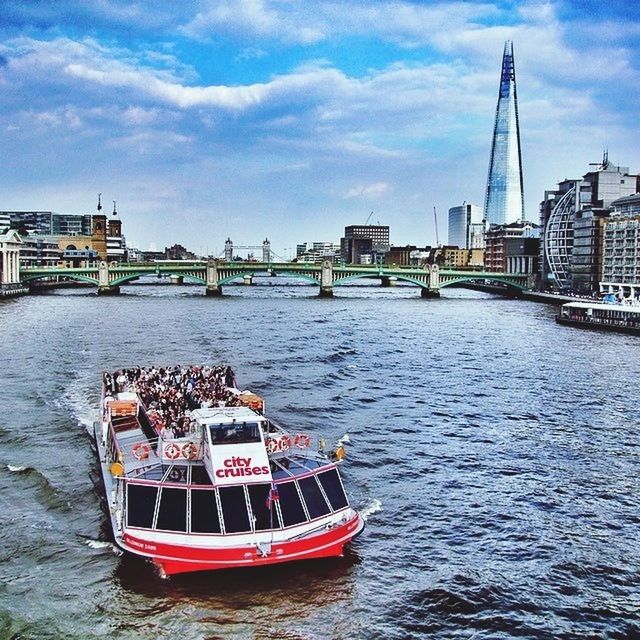 BOATS IN RIVER WITH CITY IN BACKGROUND