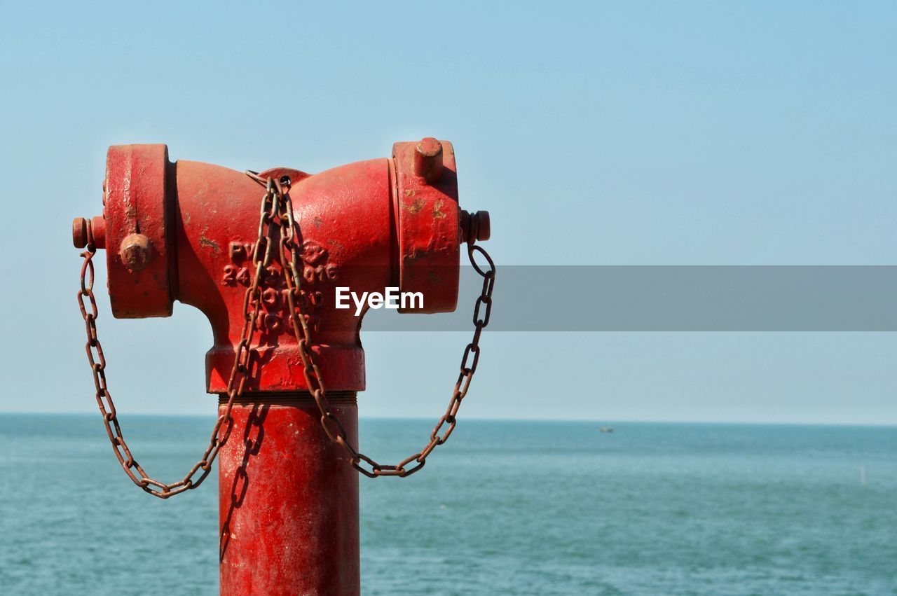 RED METAL ON SEA AGAINST CLEAR SKY