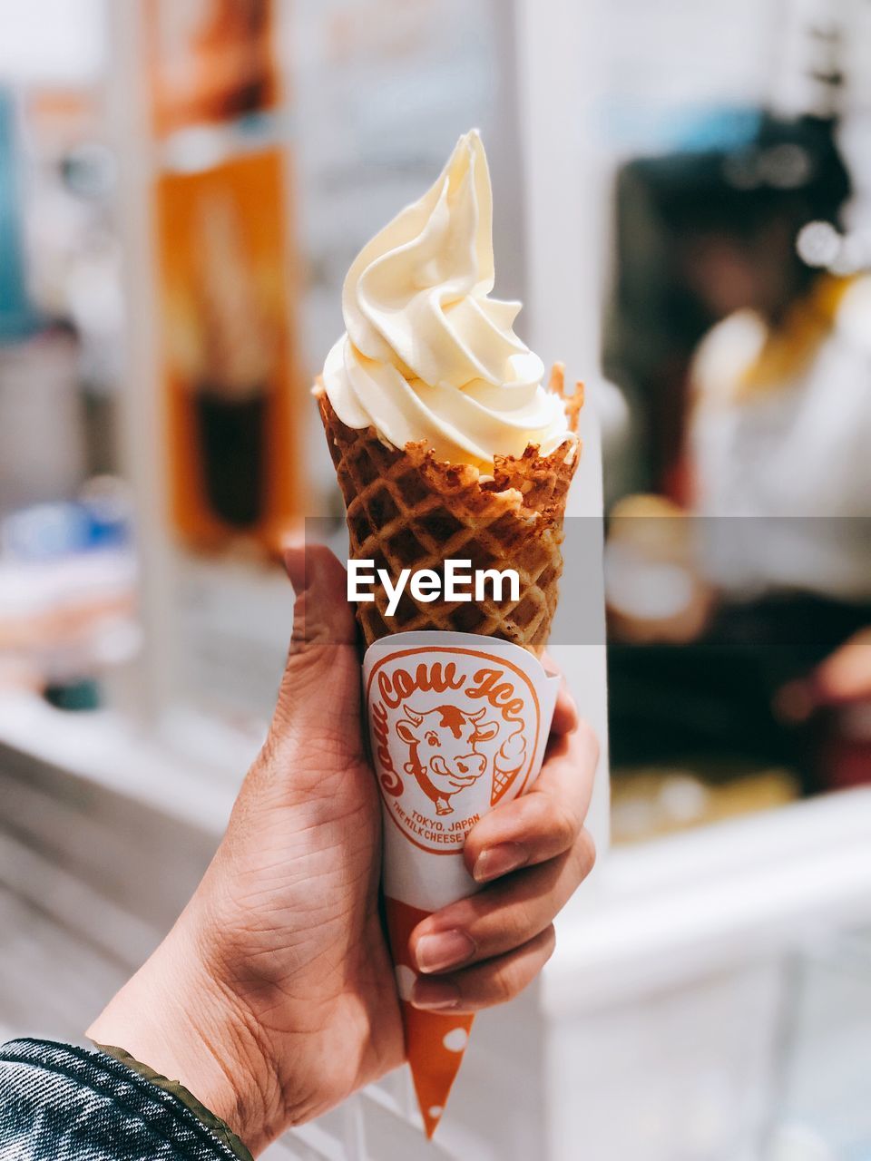 CLOSE-UP OF HAND HOLDING ICE CREAM