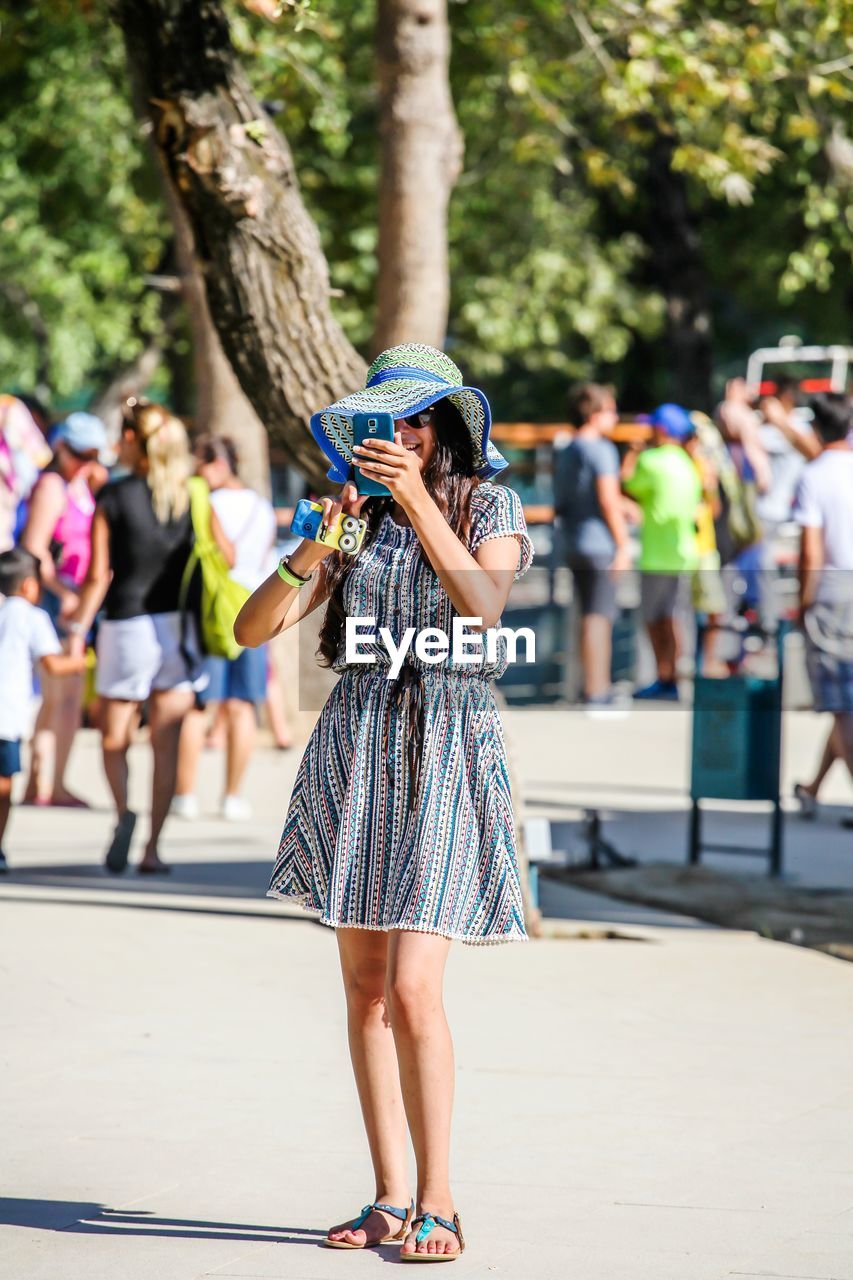 FULL LENGTH REAR VIEW OF WOMAN WALKING ON STREET