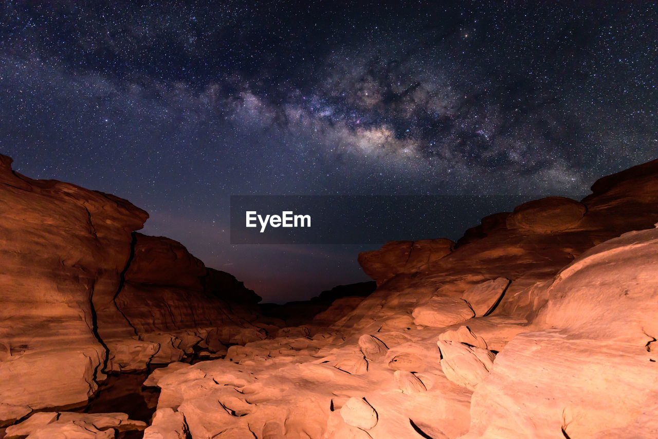 Scenic view of rock formation against sky at night