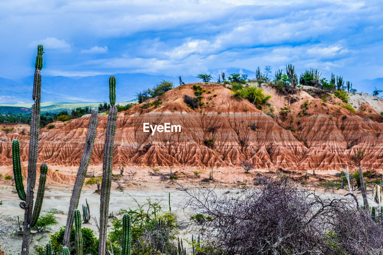 Scenic view of hill against cloudy sky