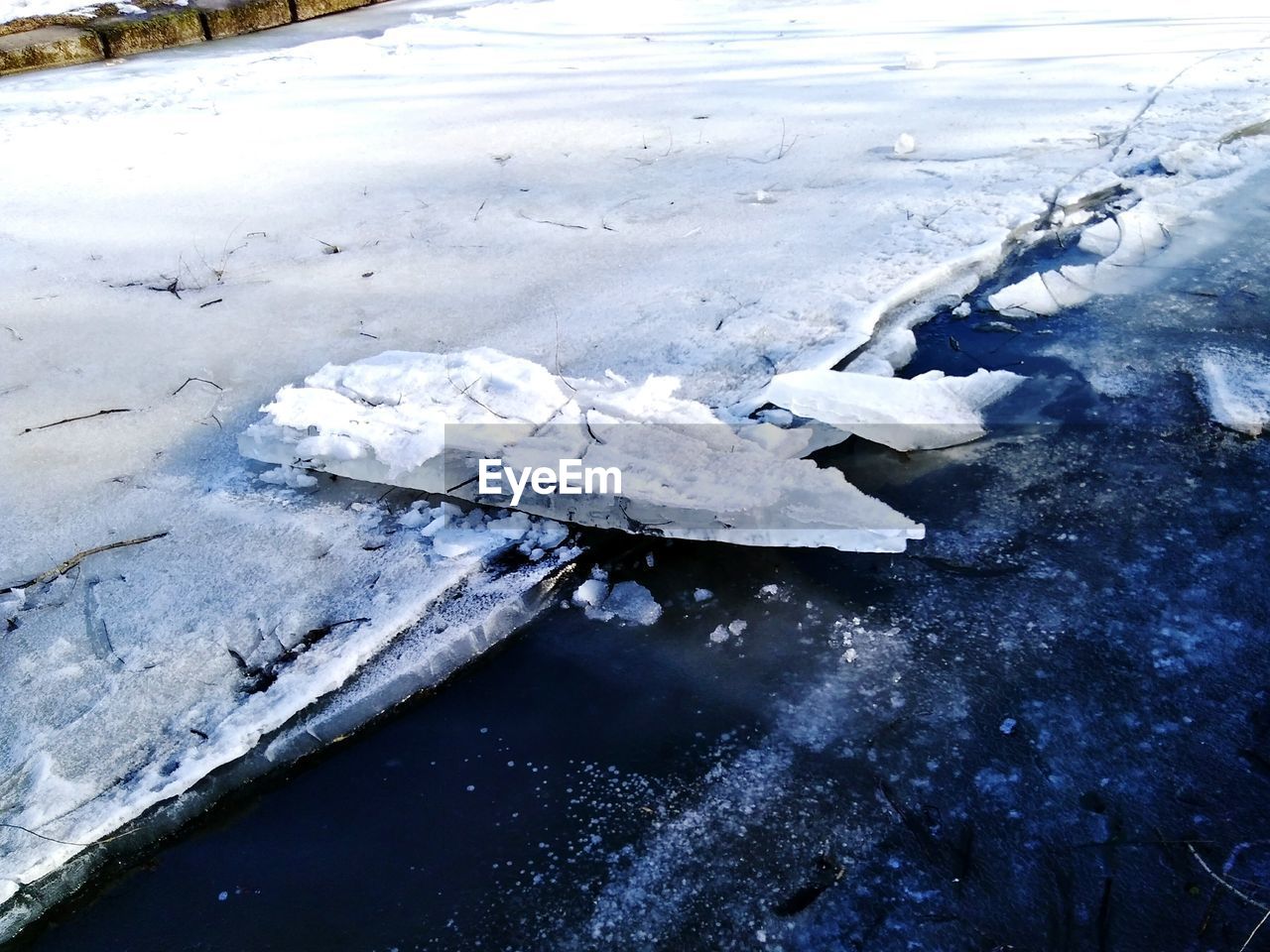 HIGH ANGLE VIEW OF FROZEN WATER ON SNOW